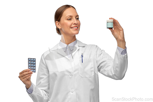 Image of smiling female doctor holding medicine pills