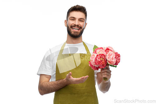 Image of smiling male gardener with bunch of peony flowers