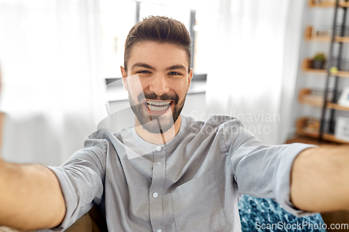 Image of man taking selfie or having video call at home