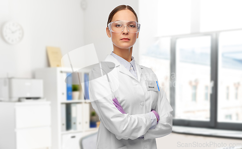 Image of female doctor in goggles and gloves at hospital