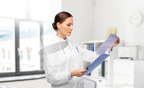 Image of female doctor with medical report at hospital