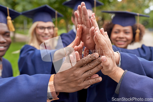 Image of international graduate students making high five