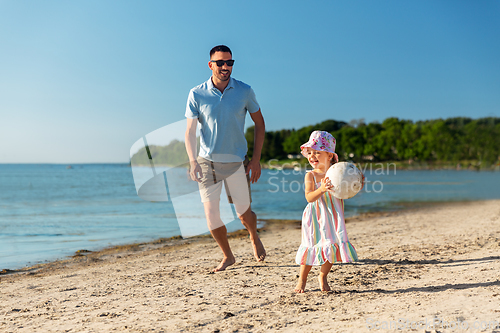 Image of happy father and daughter playing ball on beach