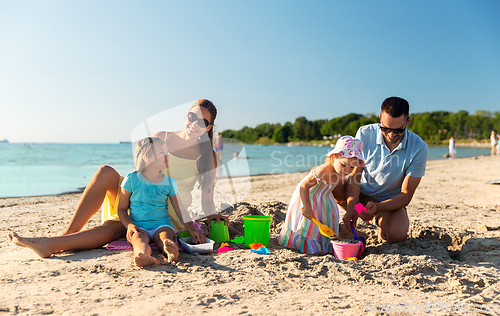 Image of happy family with daughters on summer beach