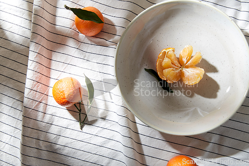 Image of still life with mandarins on plate over drapery