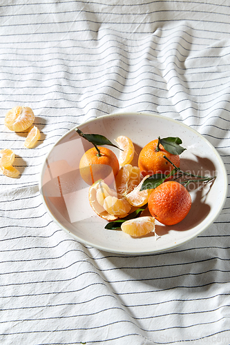 Image of still life with mandarins on plate over drapery