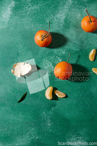 Image of still life with mandarins on green background