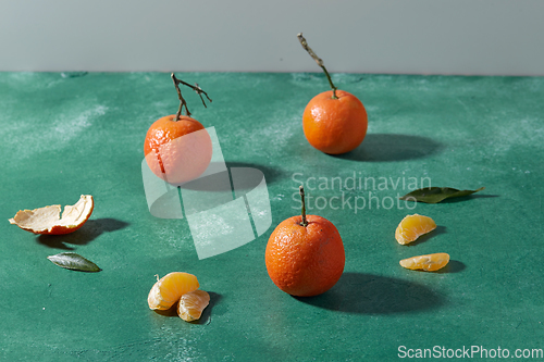 Image of still life with mandarins on green background