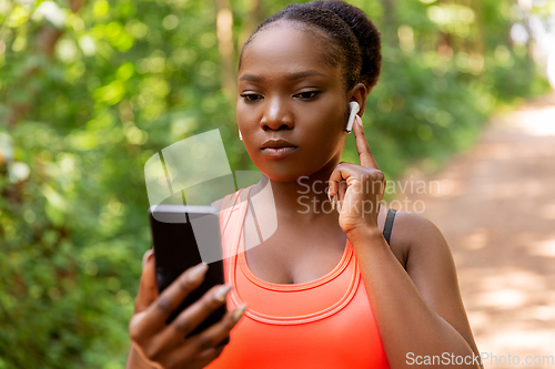 Image of african american woman with earphones and phone