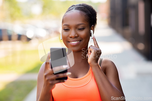 Image of african american woman with earphones and phone