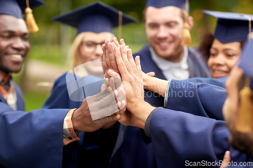 Image of international graduate students making high five