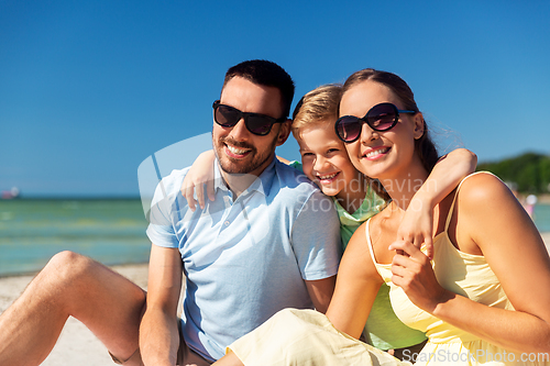 Image of family hugging on summer beach