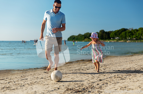 Image of happy father and daughter playing ball on beach