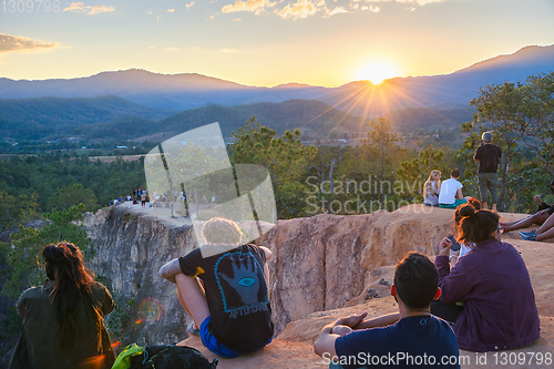 Image of People watching sunset over mountains 