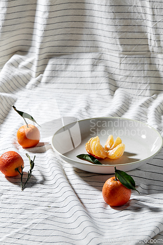 Image of still life with mandarins on plate over drapery