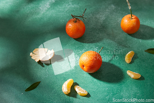 Image of still life with mandarins on green background