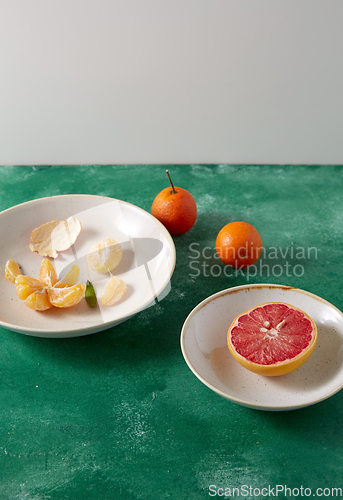 Image of peeled mandarins and grapefruit on plates