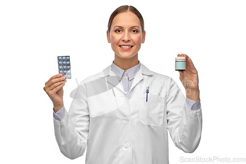 Image of smiling female doctor holding medicine pills