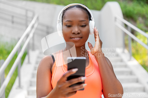 Image of african american woman with headphones and phone