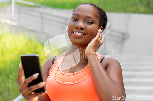 Image of african american woman with earphones and phone