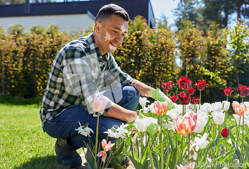 Image of man with vitiligo growing flowers at garden