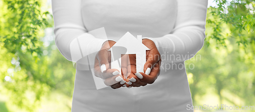 Image of hands of african american woman holding house