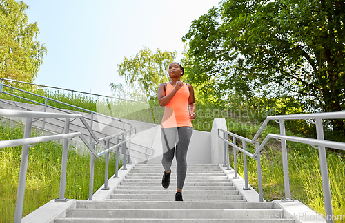 Image of young african american woman running downstairs