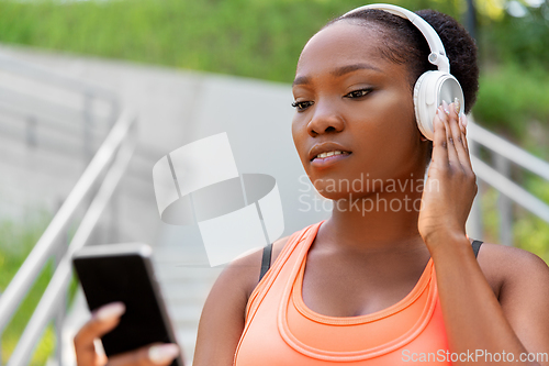 Image of african american woman with headphones and phone