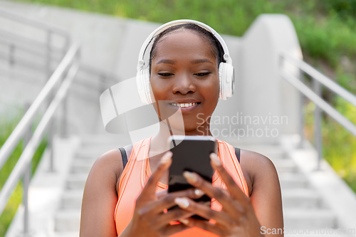 Image of african american woman with headphones and phone
