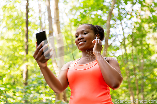 Image of african american woman with earphones and phone