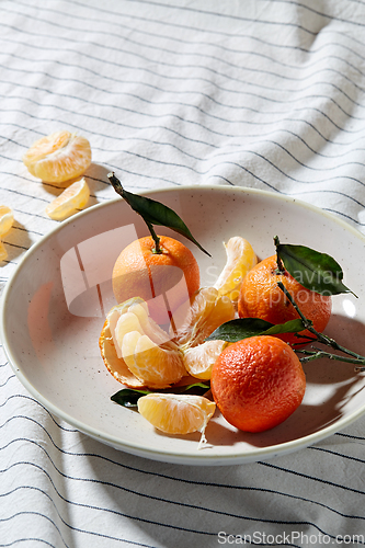 Image of still life with mandarins on plate over drapery