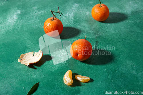 Image of still life with mandarins on green background