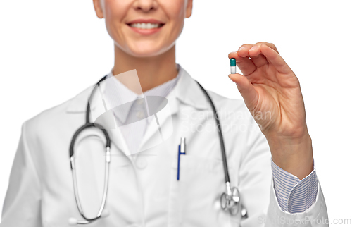 Image of smiling female doctor holding medicine pill