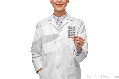 Image of smiling female doctor holding medicine pills