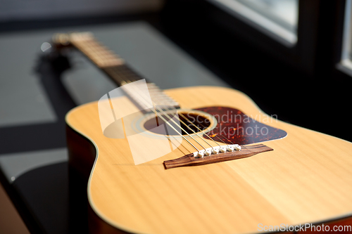 Image of close up of acoustic guitar on window sill