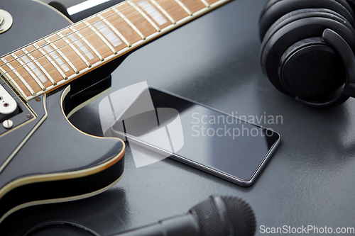 Image of close up of bass guitar and smartphone