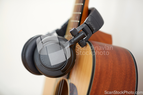 Image of close up of acoustic guitar and headphones