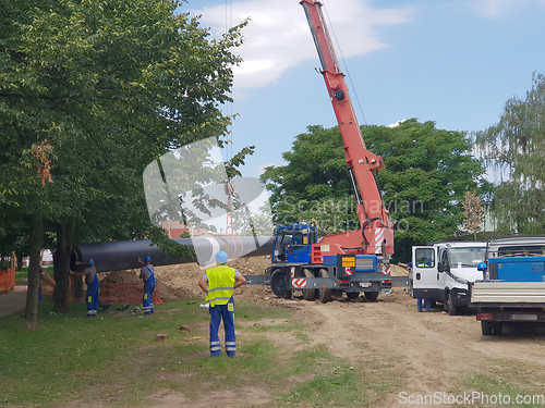 Image of Laying heating pipes in a trench at construction site. Reconstru