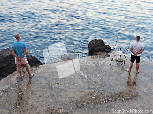 Image of Two fishermen are waiting for the fish to bite