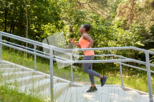 Image of young african american woman running upstairs