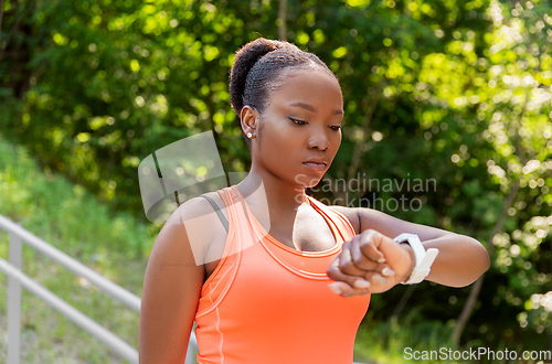 Image of african woman with smart watch doing sports