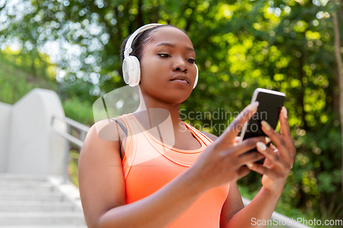 Image of african american woman with headphones and phone