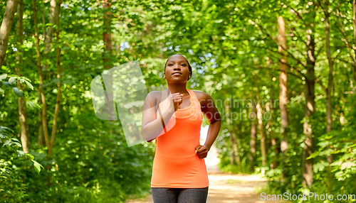 Image of young african american woman running in forest