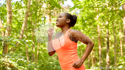 Image of happy african american woman running in forest