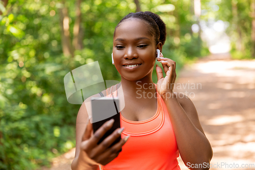 Image of african american woman with earphones and phone