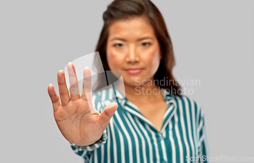 Image of close up of asian woman showing stop gesture