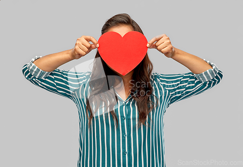 Image of woman covering her face with red heart