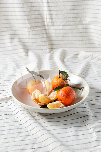 Image of still life with mandarins on plate over drapery