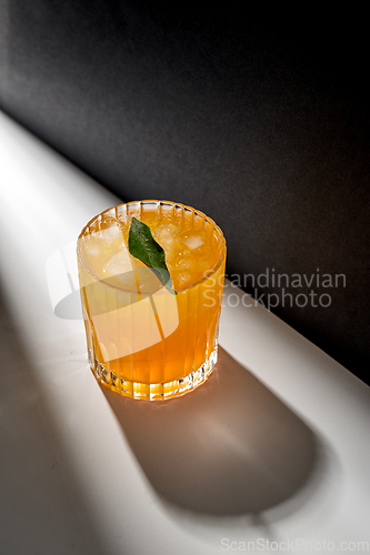 Image of glass of orange juice with ice on table