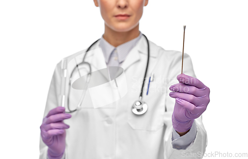 Image of female doctor with cotton swab and test tube